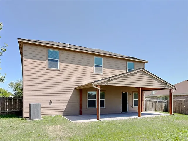 a view of a house with a yard and wooden fence