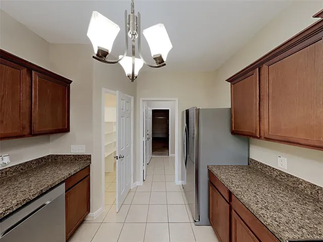 a kitchen with stainless steel appliances granite countertop a sink a counter space and cabinets