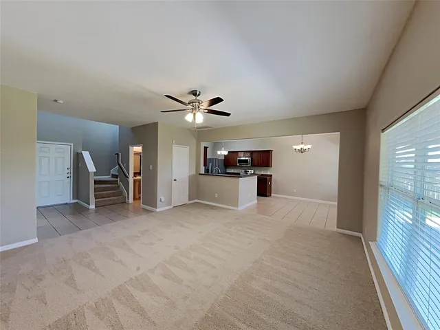 a view of empty room with kitchen and window