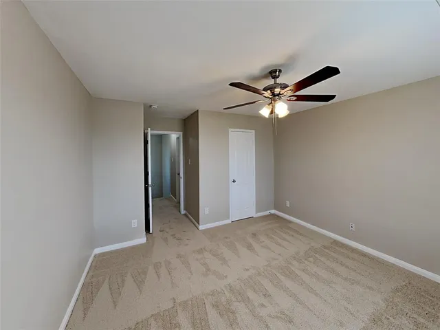 a view of an empty room with a ceiling fan