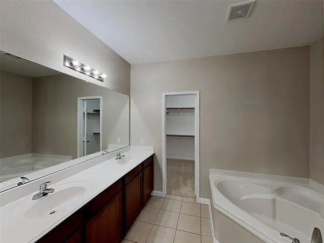 a spacious bathroom with a bathtub sink and mirror