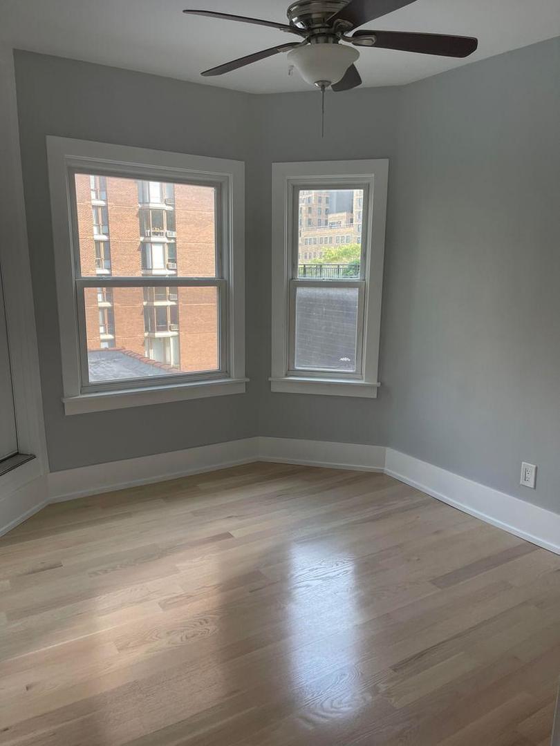 67 West Chestnut Street, Unit 4 Chicago, IL 60610 - Photo 11 of 13 an empty room with wooden floor windows and fan