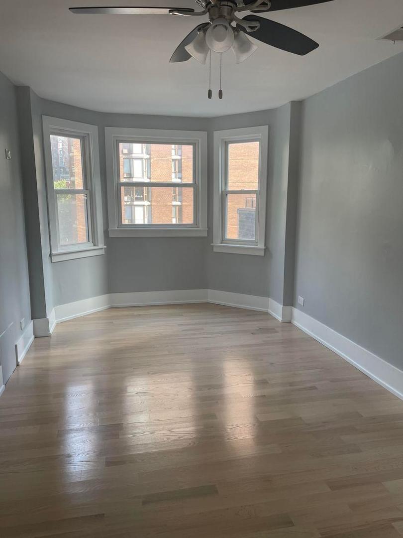 67 West Chestnut Street, Unit 4 Chicago, IL 60610 - Photo 4 of 13 an empty room with wooden floor and windows