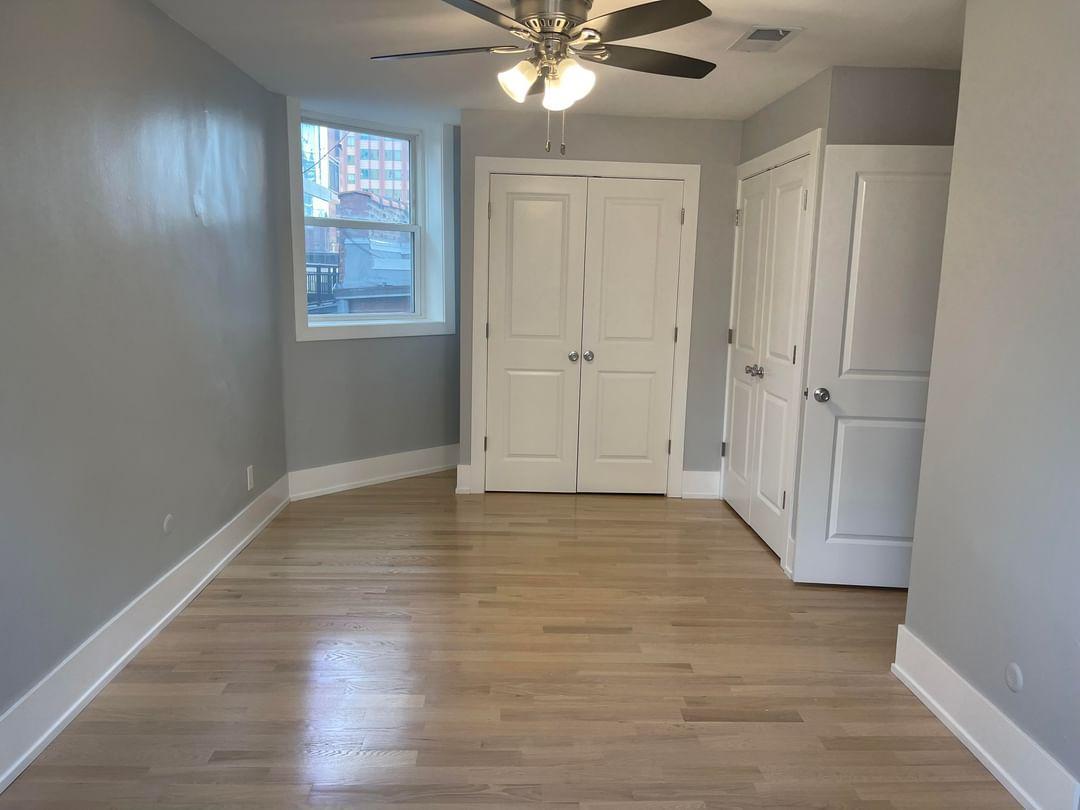67 West Chestnut Street, Unit 4 Chicago, IL 60610 - Photo 6 of 13 a view of an empty room with wooden floor and a window