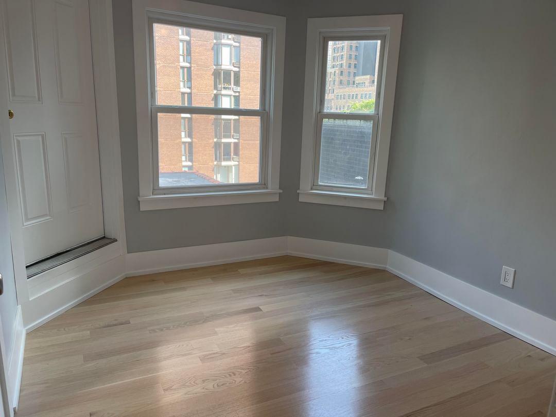 67 West Chestnut Street, Unit 4 Chicago, IL 60610 - Photo 7 of 13 a view of an empty room with wooden floor and a window