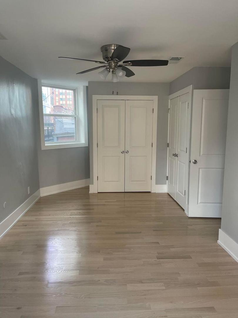 67 West Chestnut Street, Unit 4 Chicago, IL 60610 - Photo 9 of 13 a view of empty room with wooden floor and fan