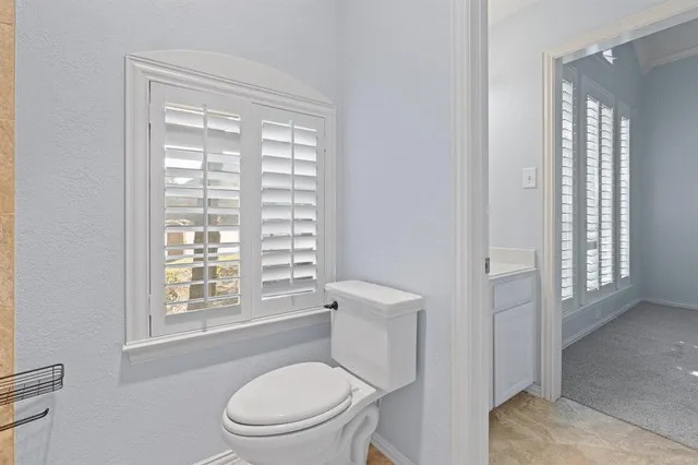 a white toilet sitting next to a window