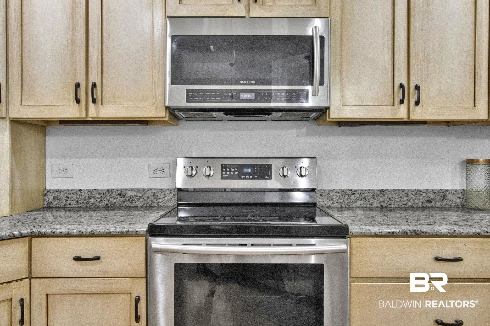 9002 Parliament Circle Daphne, AL 36526 - Photo 29 of 73 Kitchen with light stone countertops, appliances with stainless steel finishes, and light brown cabinets
