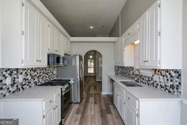 a kitchen with granite countertop a sink and a refrigerator
