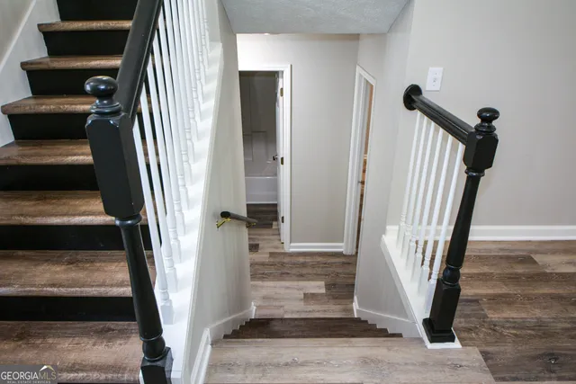 a view of a hallway with wooden floor and entryway