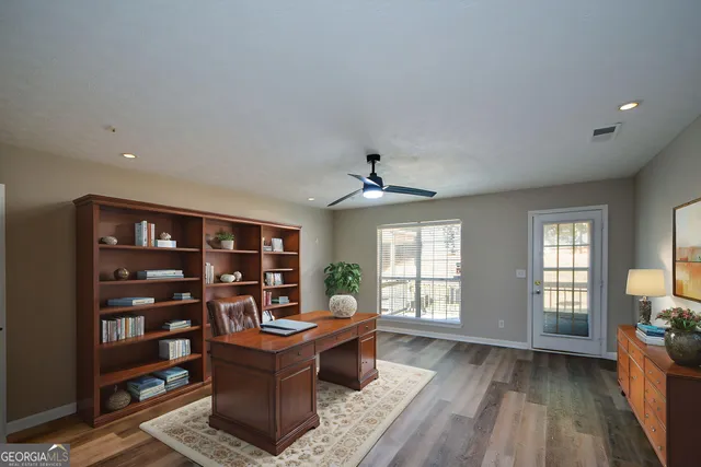 a living room with furniture a bookshelf and a window