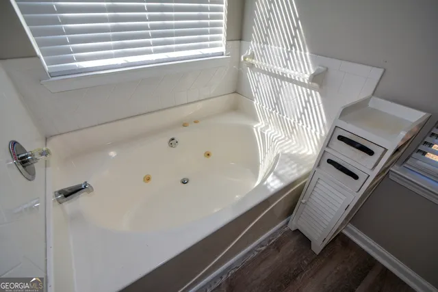 a spacious bathroom with a granite countertop sink mirror and a large window