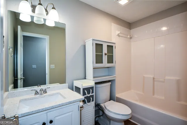 an empty room with closet and a ceiling fan