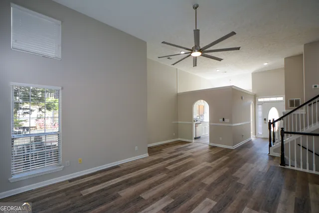 a view of a livingroom with wooden floor and a ceiling fan