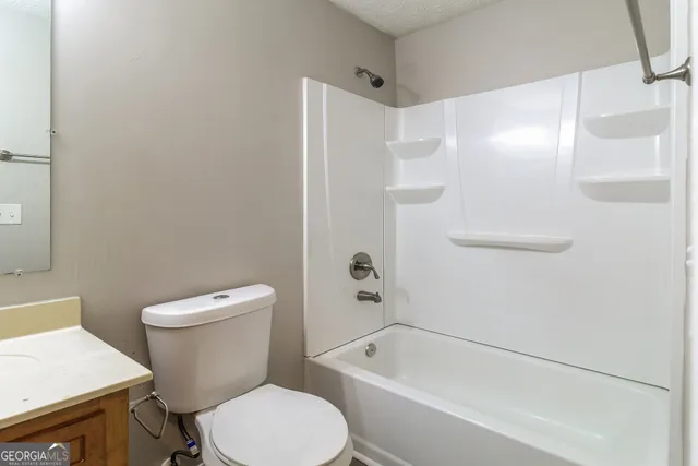 a white toilet sitting next to a bath tub
