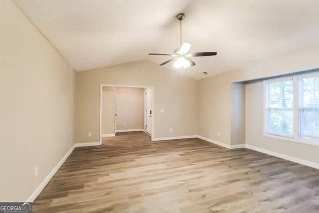 an empty room with fan and windows