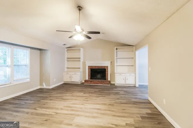 a view of an empty room with a fireplace and a window