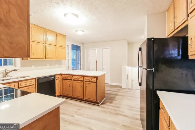 a kitchen with stainless steel appliances granite countertop a refrigerator a sink dishwasher a stove with wooden cabinets