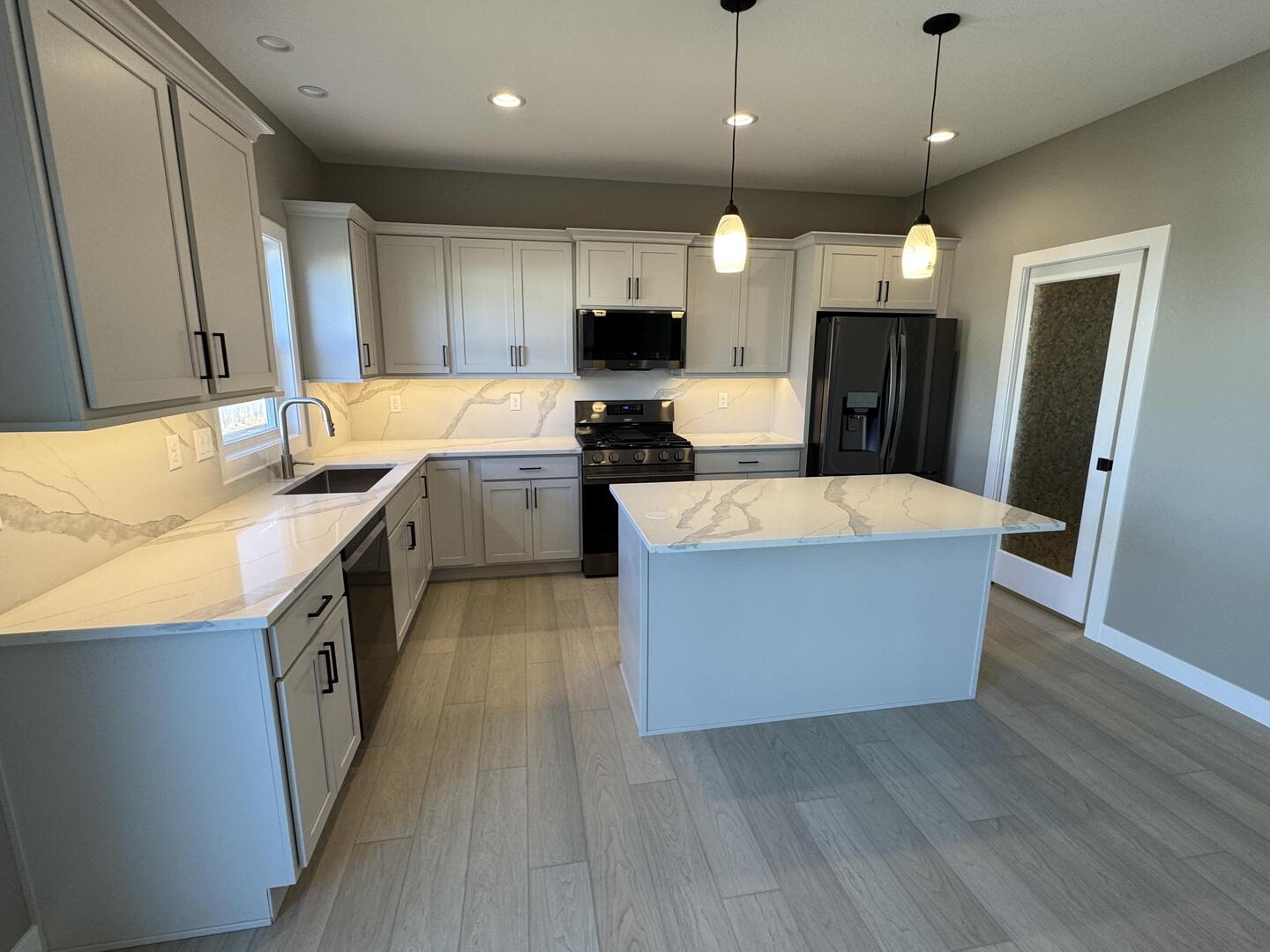 3618 Cabernet Court Normal, IL 61761 - Photo 11 of 16 a large kitchen with stainless steel appliances kitchen island a large counter top and wooden floor
