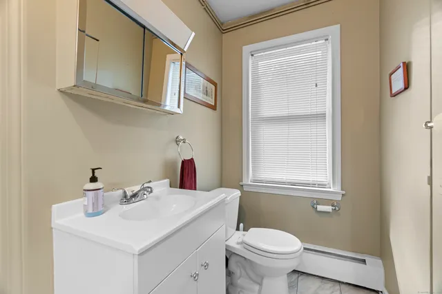 a bathroom with a toilet sink and mirror