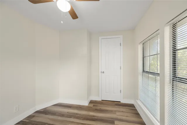 a view of a room with wooden floor and windows