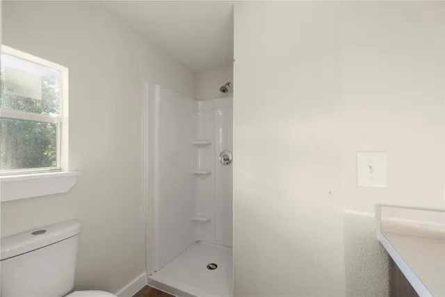 a bathroom with a shower a toilet and sink