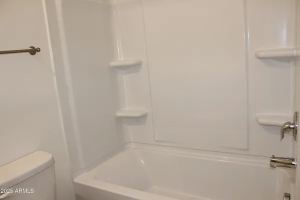 a white bath tub sitting next to a white toilet