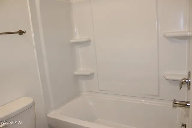 a white bath tub sitting next to a white toilet