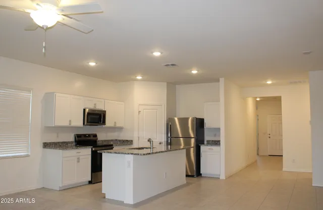 a kitchen with stainless steel appliances kitchen island a refrigerator sink and microwave