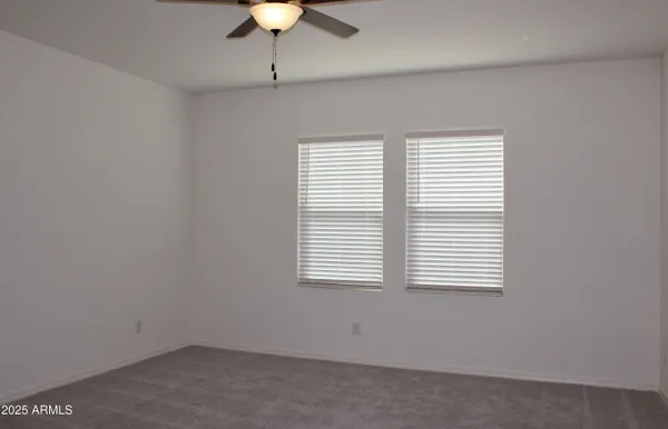 an empty room with a window and a fan