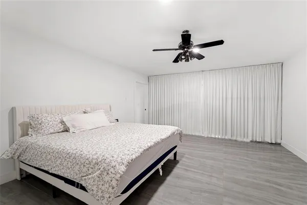 a bedroom with a bed chandelier and wooden floor