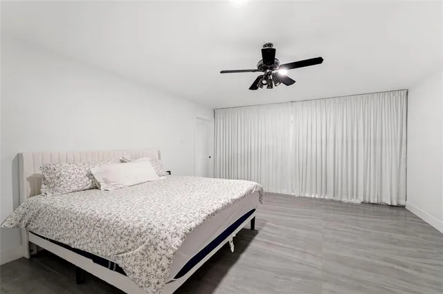 a bedroom with a bed chandelier and wooden floor