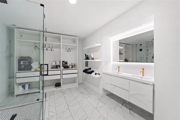 a large white bathroom with a double vanity sink a mirror and a bathtub