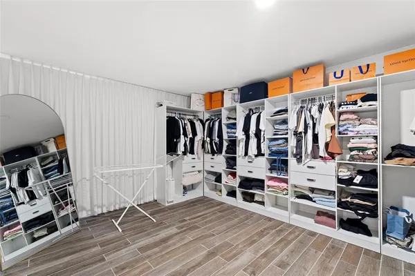 a view of walk in closet with clothes and shoes