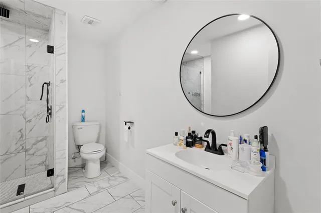 a bathroom with a sink a toilet and a mirror