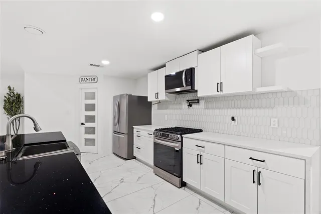a kitchen with a sink stainless steel appliances and cabinets