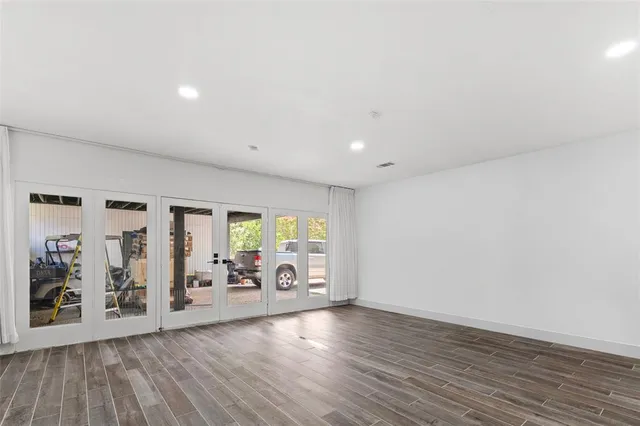 an empty room with furniture and large window