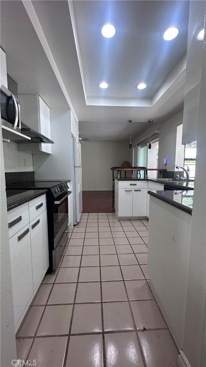 5 Glenhurst, Unit 5 Irvine, CA 92604 - Photo 7 of 16 a kitchen with stainless steel appliances granite countertop a stove a sink and a refrigerator