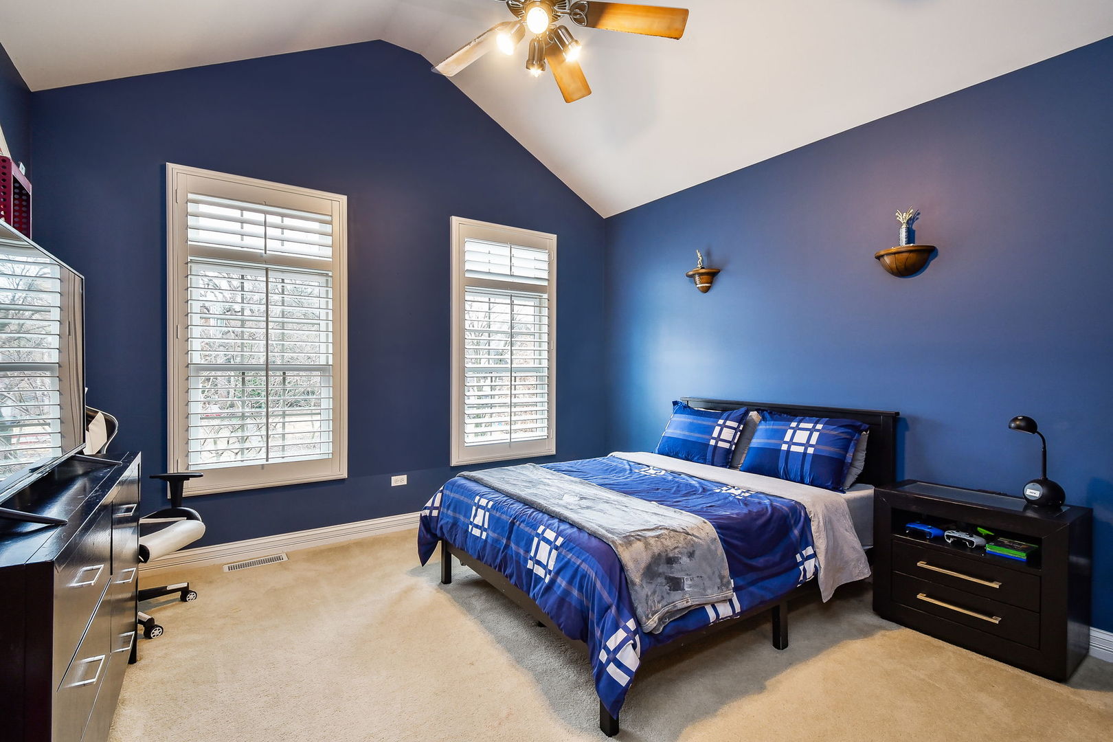 821 Wellner Road Naperville, IL 60540 - Photo 26 of 56 a bedroom with a bed and a chandelier