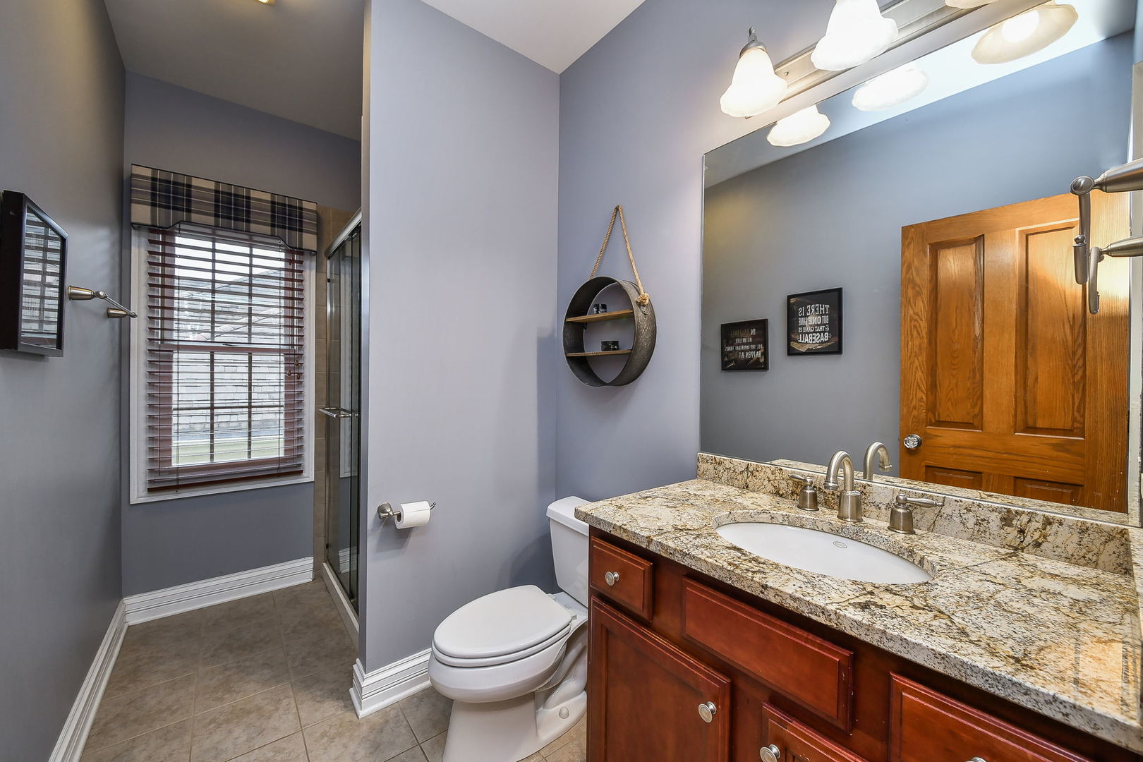 821 Wellner Road Naperville, IL 60540 - Photo 27 of 56 a bathroom with a granite countertop sink a toilet and a mirror