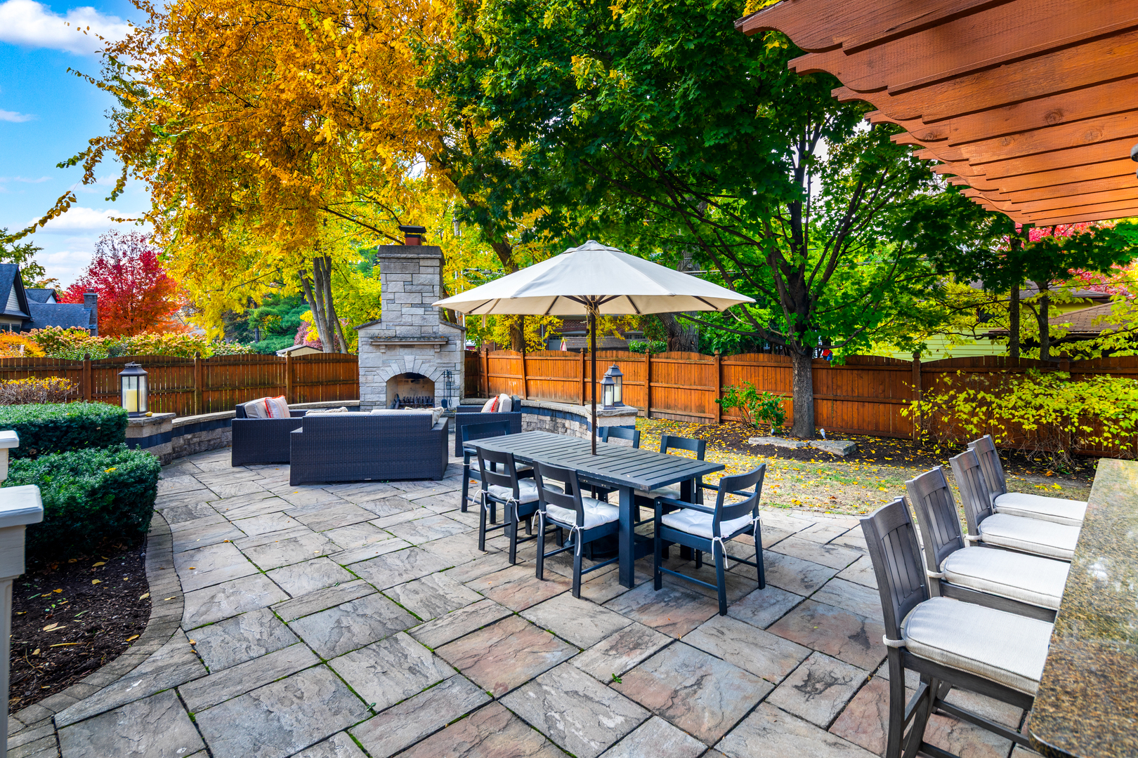 821 Wellner Road Naperville, IL 60540 - Photo 47 of 56 a view of a patio with a dining table and chairs under an umbrella with a barbeque