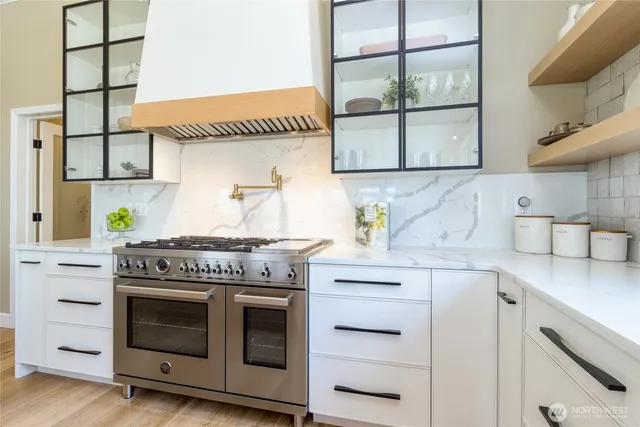 a kitchen with stainless steel appliances granite countertop a stove and a white cabinets