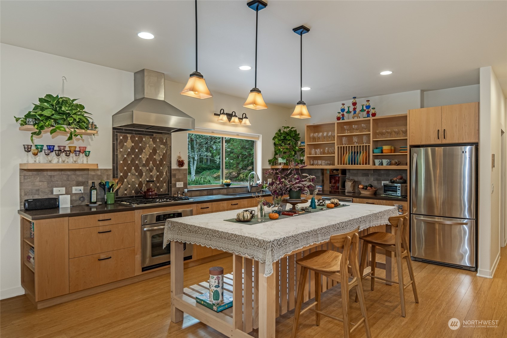 150 Carter Beach Road Friday Harbor, WA 98250 - Photo 17 of 39 a kitchen with stainless steel appliances granite countertop a stove a sink a refrigerator and a dining table with wooden floor