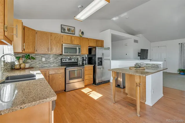 a kitchen with stainless steel appliances granite countertop a sink stove and refrigerator