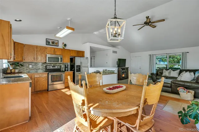 a kitchen with a dining table chairs and white cabinets