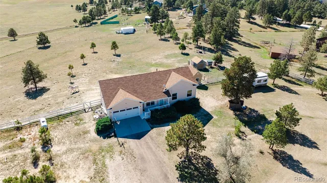an aerial view of a house with a yard covered with snow