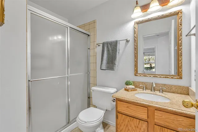 a bathroom with a granite countertop sink toilet and shower