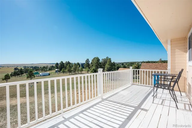 a view of a balcony with wooden floor and fence