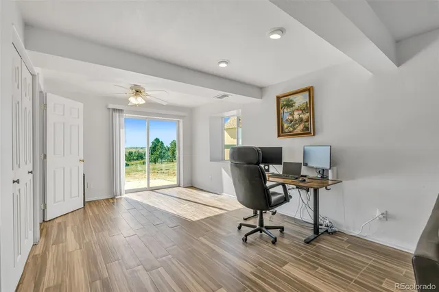 a view of a workspace with wooden floor and a window