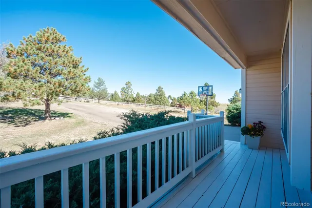 a view of a balcony with wooden floor and fence